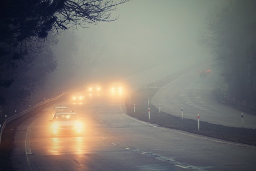 Cars driving in the fog.